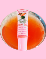 Barely crusty lip balm over a martini glass with watermelon drink in it on a pink background